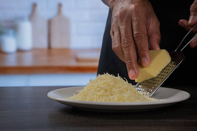 tangan memarut keju segar di dapur modern - keju cheddar indonesia potret stok, foto, &amp; gambar bebas royalti