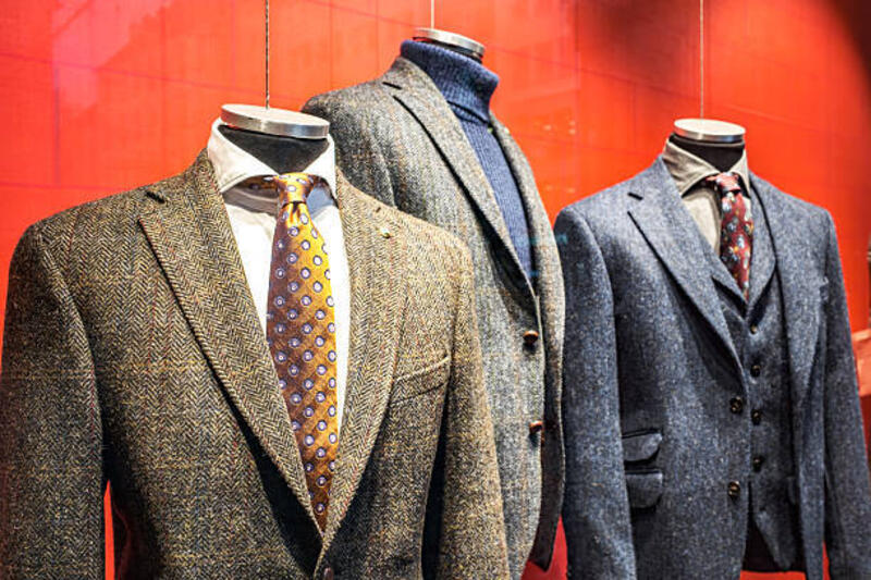 Mannequins displaying stylish jackets and suits in a shop window of an Austrian boutique during the winter season Mannequins showcase a variety of fashionable jackets and suits in a store display in Austria, highlighting winter styles with vibrant colors against a bold red background. suit wool stock pictures, royalty-free photos &amp; images