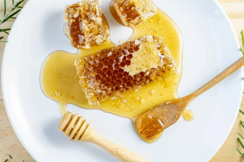 Sweet Honeycomb di piring kayu dengan latar belakang kayu, Yellow Honeycomb di atas meja kayu.