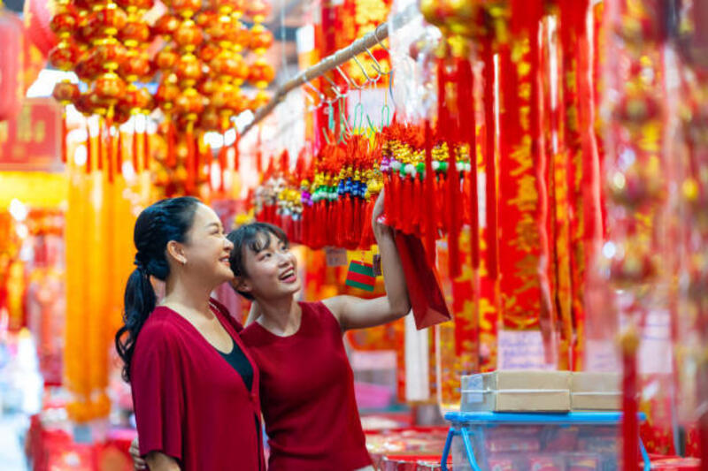 Ibu dan anak Asia membeli barang-barang untuk merayakan festival Tahun Baru Imlek di Chinatown