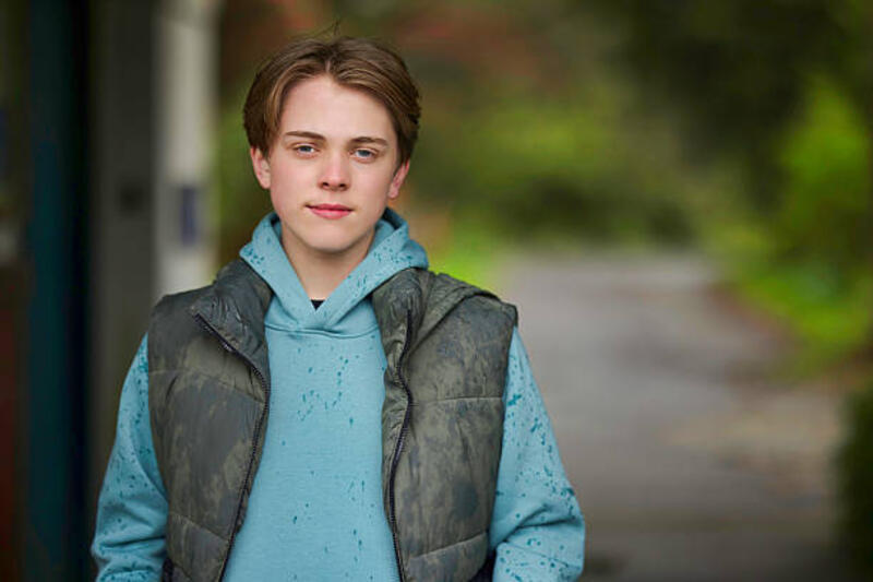 Remaja laki-laki di luar ruangan pada hari hujan