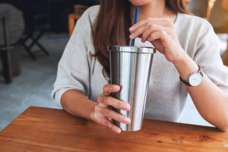a woman drinking coffee in stainless steel cup Closeup image of a woman drinking coffee in stainless steel cup coffee glass stock pictures, royalty-free photos &amp; images