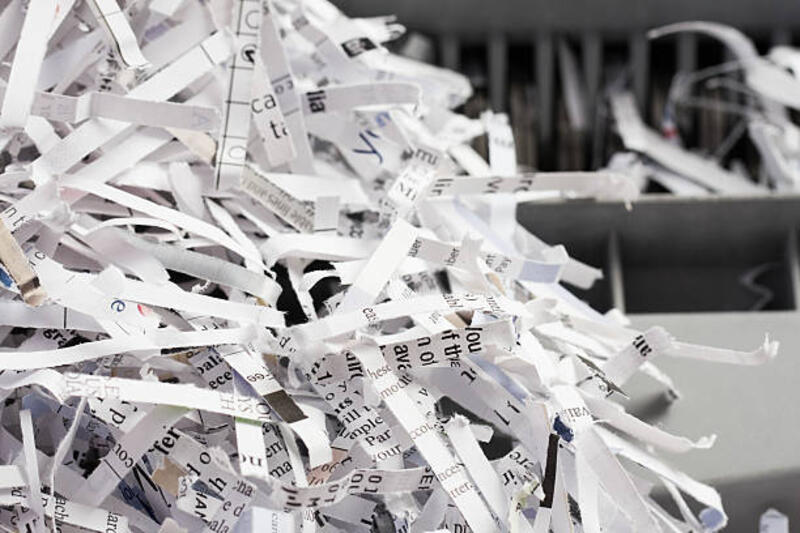 Pile of Shredded Paper with Shredder in Background Close up image of a pile of shredded paper documents in front of a paper shredder. paper shredder stock pictures, royalty-free photos &amp; images