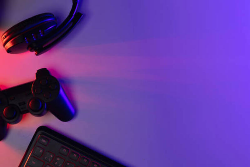 Aksesori keyboard gaming joystick mouse headphone dengan ruang kosong. Gadget untuk gamer yang bermain video game online di kamar gelap neon light.