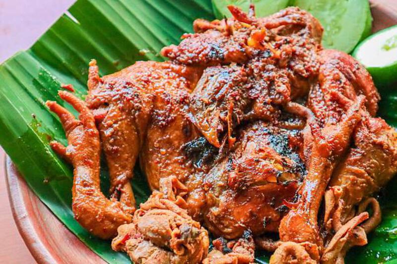 Traditional indonesian spicy grilled whole chicken on banana leaf A close-up view of traditional Indonesian spicy grilled whole chicken, locally known as Ayam Bakar, served on a vibrant green banana leaf, highlighting its rich textures and seasonings. ayam bakar stock pictures, royalty-free photos &amp; images