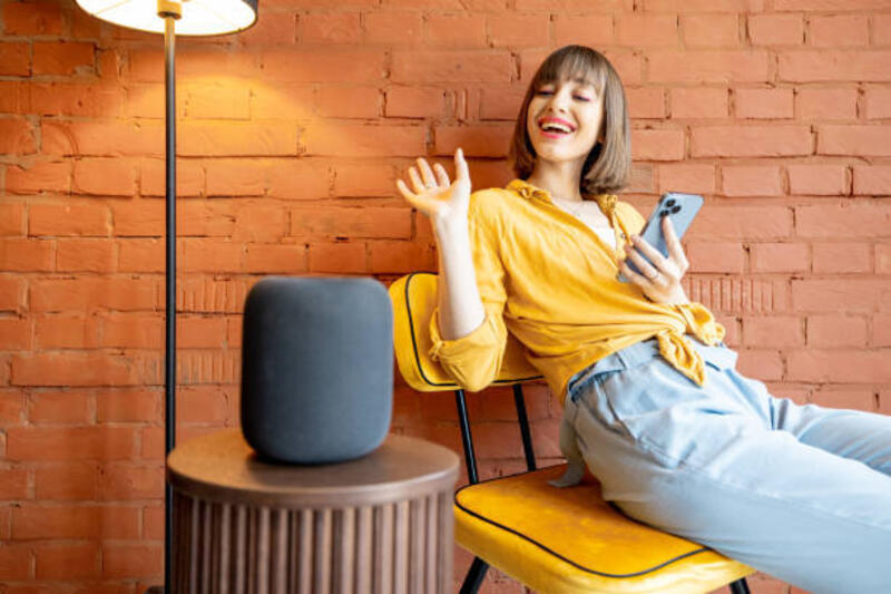 wanita-dengan-speaker-pintar-dan-telepon-di-rumah.jpg (612×408)
