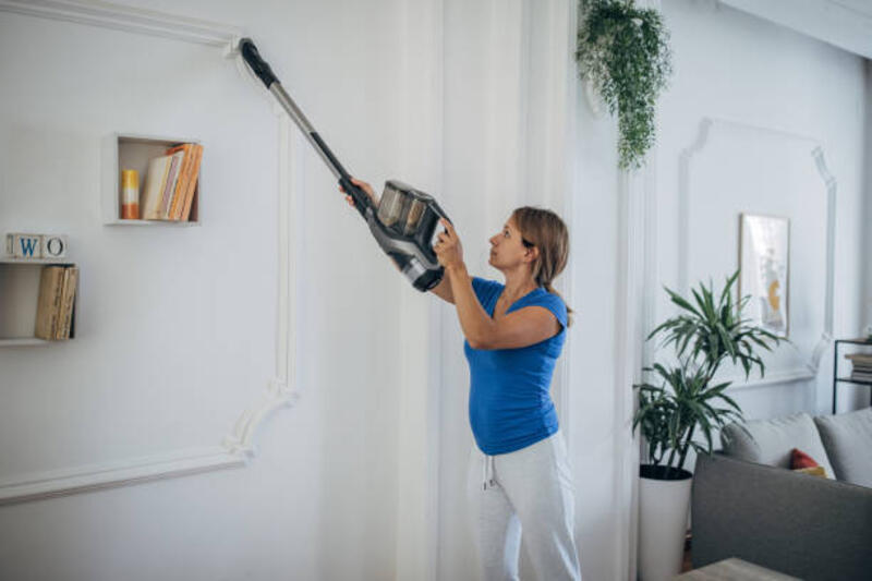 wanita bule muda membersihkan rumah dengan penyedot debu tongkat tanpa kabel - cordless vacuum cleaner potret stok, foto, &amp; gambar bebas royalti