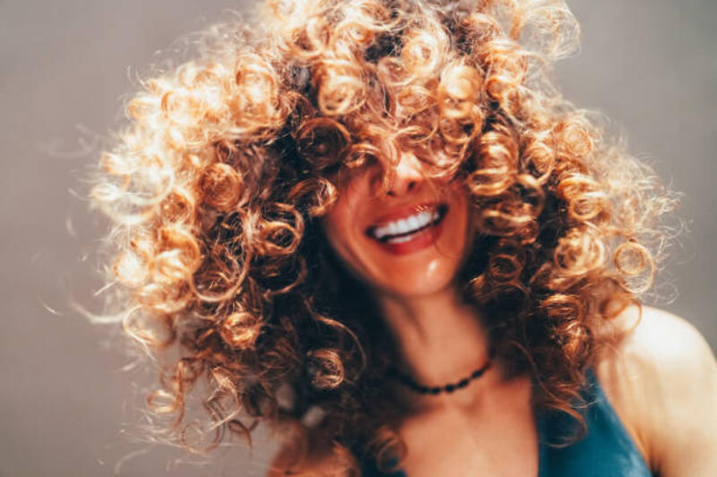 Woman with curly hair taking selfie Smiling woman with curly hair taking selfie curly hair stock pictures, royalty-free photos &amp; images