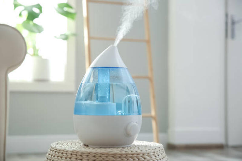 Humidifier udara modern pada anyaman pouf di dalam ruangan
