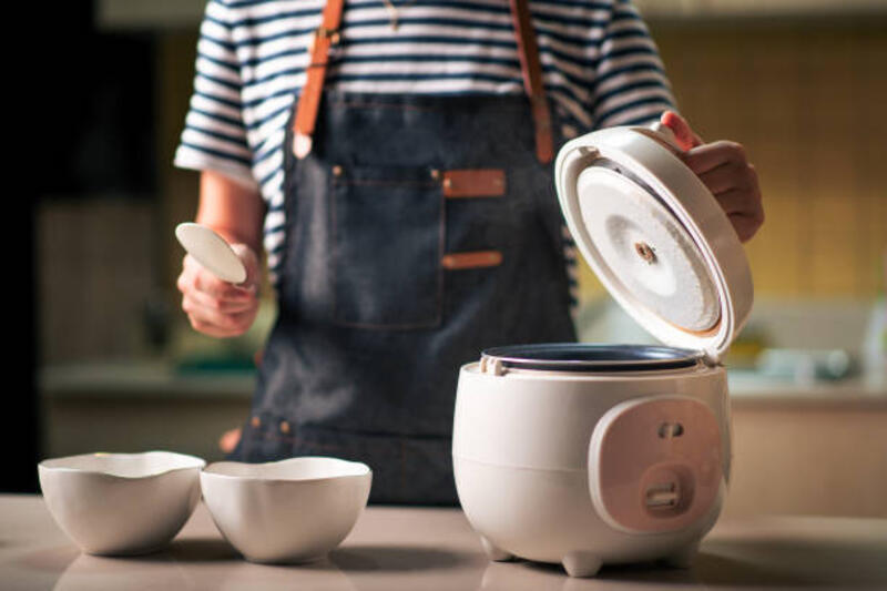 wanita mengambil dan menyajikan nasi rebus segar dari kompor - cooking with mini rice cooker potret stok, foto, & gambar bebas royalti