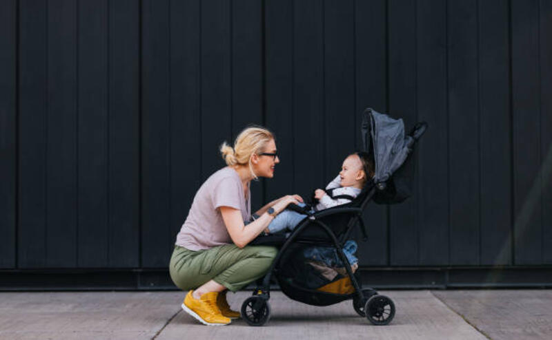 ibu menyesuaikan sabuk di stroller untuk putrinya - stroller bayi potret stok, foto, &amp; gambar bebas royalti