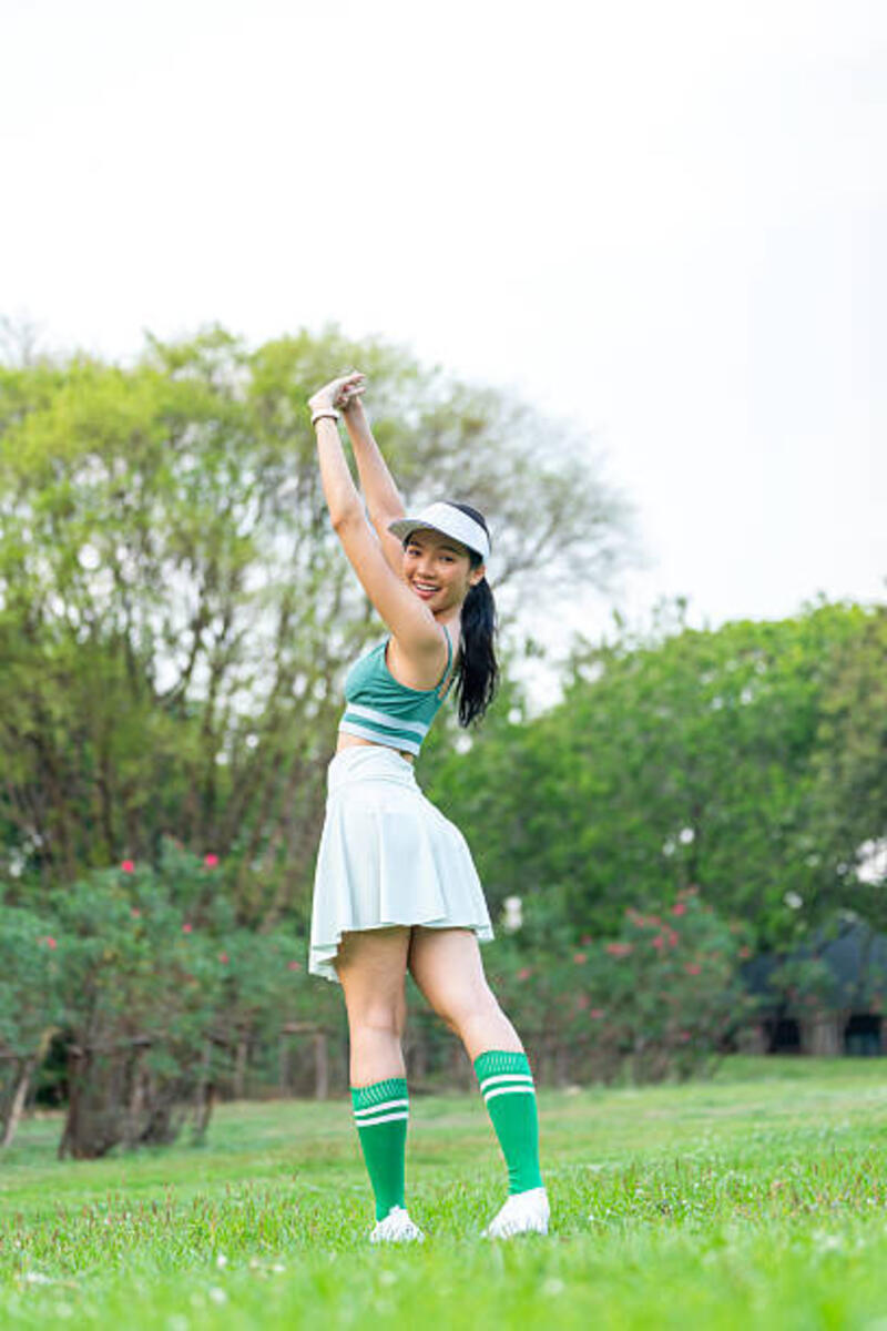 young woman in green activewear and visor cap enjoying nature in the park - skort wanita potret stok, foto, &amp; gambar bebas royalti