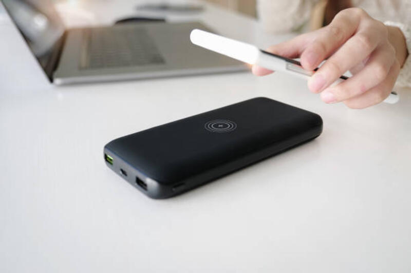 Smartphone Pengisian Daya Wanita Menggunakan Pengisian Cepat Nirkabel portabel di tempat kerja