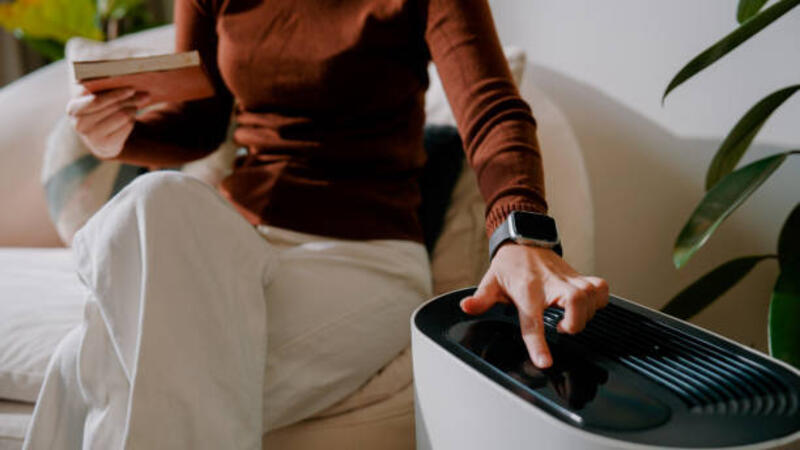 young-asian-woman-pressing-the-on-button-on-air-purifier-before-starting-to-read-a-book.jpg (612×344)