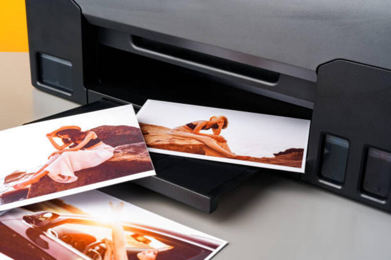 Modern laser printer printing color photos of women close up