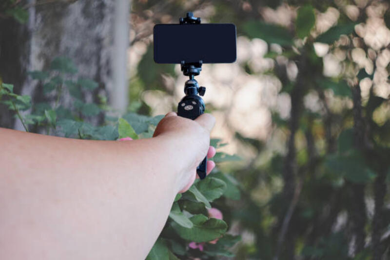 tangan-memegang-ponsel-pada-tripod-di-latar-belakang-alam.jpg (612×408)