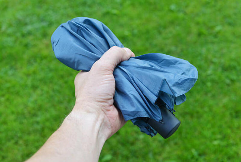 Compact Umbrella in Hand Closeup of a man
