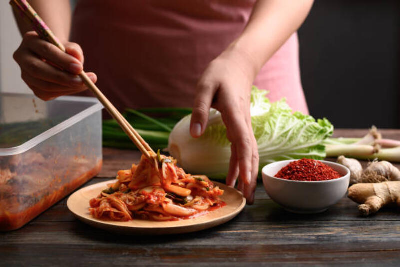 Woman hand picking kimchi cabbage by chopsticks Woman hand picking kimchi cabbage by chopsticks on wooden plate for eating, Homemade Korean food kimchi stock pictures, royalty-free photos &amp; images