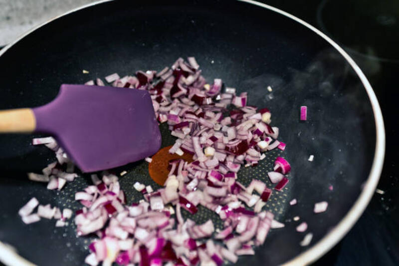 bawang merah memasak dalam wajan anti lengket - alat masak silikon potret stok, foto, &amp; gambar bebas royalti