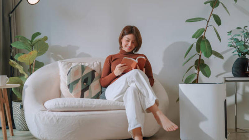 Asian woman reading a book at home