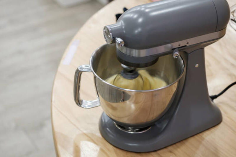 Mencampur telur, tepung dan gula dalam mangkuk dengan mixer motorik. Menyiapkan bahan-bahan untuk memanggang kue.