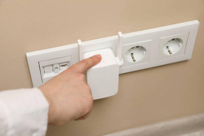 wanita menyalakan repeater wi-fi nirkabel di dalam ruangan, closeup - wifi range extender potret stok, foto, & gambar bebas royalti