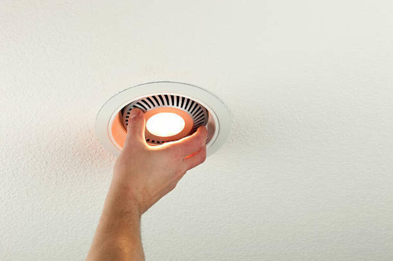 Installing LED Light Bulb into Ceiling Fixture "A male hand is installing an energy efficient LED light bulb into a ceiling can fixture. This would be the typical style built-in lighting found in many modern homes, the LED is replacing a standard incandescent bulb. LEDs, although more costly, appear to be the light of the future. Incandescent bulbs are being phased out and compact florescent bulbs are presenting disposal issues." downlight led stock pictures, royalty-free photos & images