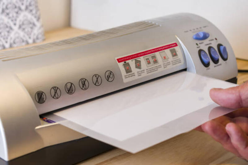 pria dewasa menggunakan mesin plastisisasi termal, tanda laminasi ke kantor - laminator paper potret stok, foto, &amp; gambar bebas royalti