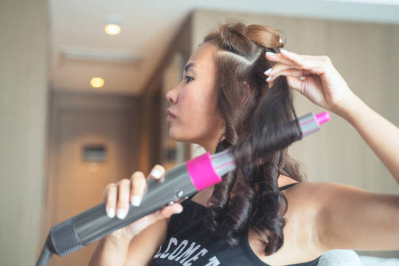 wanita menggunakan pelurus rambut - catokan curly potret stok, foto, &amp; gambar bebas royalti