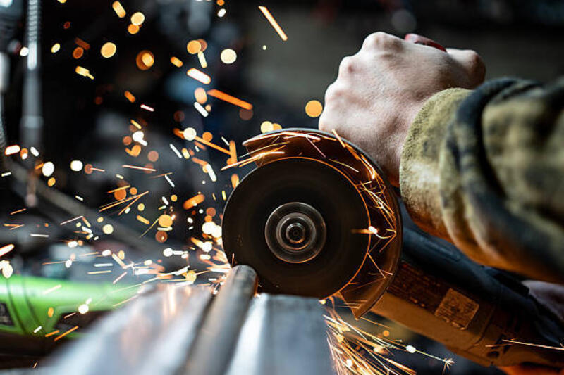 penggiling sudut pengoperasian pekerja dengan percikan api terbang selama pemotongan logam - grinding wheel potret stok, foto, &amp; gambar bebas royalti