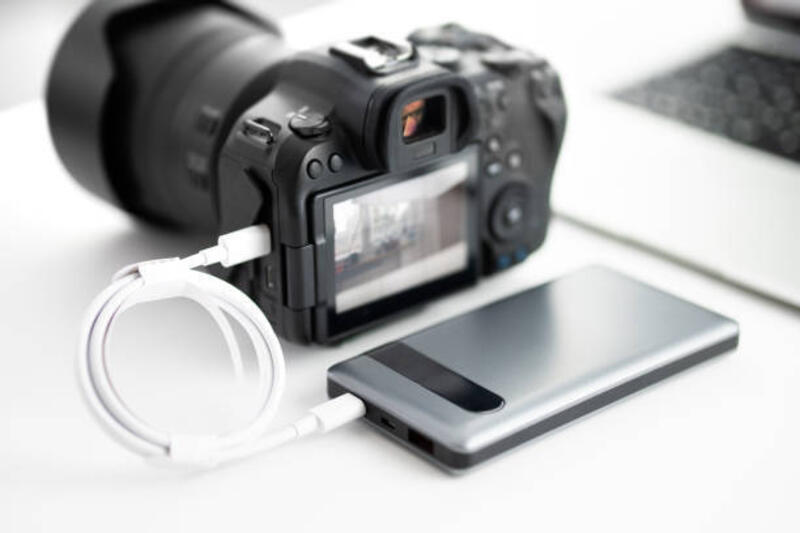 Charge/ operate the modern DSLR / mirrorless camera from a power bank charge/ operate the modern DSLR / mirrorless camera from a power bank charging camera with cable stock pictures, royalty-free photos &amp; images
