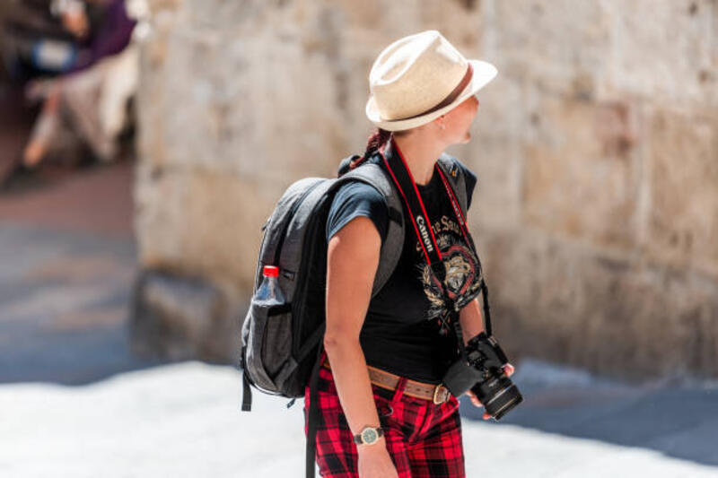 City in Tuscany with tourist people young woman sightseeing with camera photographer San Gimignano, Italy - August 27, 2018: City in Tuscany with tourist people young woman sightseeing on sunny summer day with camera photographer neck strap camera stock pictures, royalty-free photos &amp; images