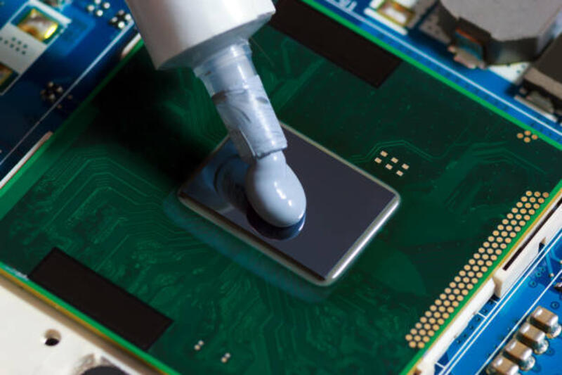 senyawa pasta termal memeras pada prosesor notebook. gemuk termal untuk pendinginan cpu yang lebih baik. - laptop thermal paste  potret stok, foto, & gambar bebas royalti