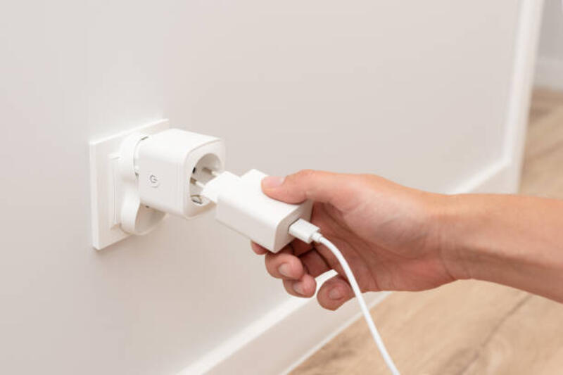 pria mencolokkan pengisi daya ke soket pintar - smart plug potret stok, foto, &amp; gambar bebas royalti