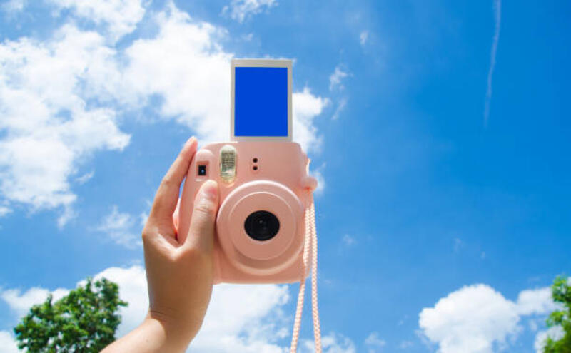 tangan memegang dan memotret bingkai foto layar kosong kamera instan dengan tampilan langit biru di latar belakang. - polaroid camera potret stok, foto, &amp; gambar bebas royalti