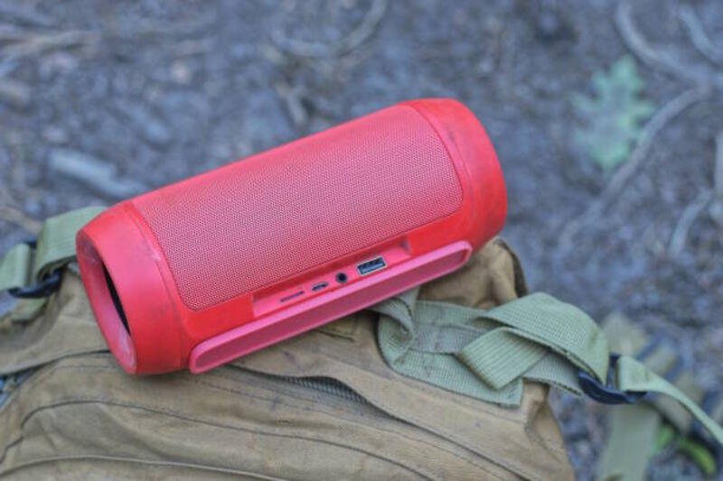 satu speaker musik plastik seluler merah terletak di ransel coklat - portable speaker potret stok, foto, &amp; gambar bebas royalti