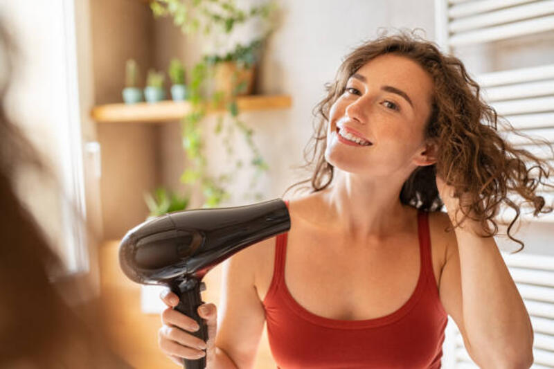 wanita tersenyum bahagia menggunakan pengering rambut di kamar mandi - hair dryer potret stok, foto, &amp; gambar bebas royalti
