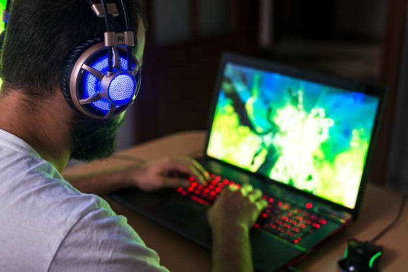 gamer muda bermain video game mengenakan headphone. - gaming laptop potret stok, foto, & gambar bebas royalti