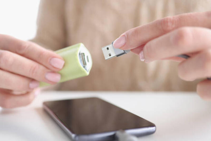 Woman hand inserts usb wire from smartphone into USB flash drive Woman hand inserts usb wire from smartphone into USB flash drive. Transferring files to memory card concept otg  stock pictures, royalty-free photos & images