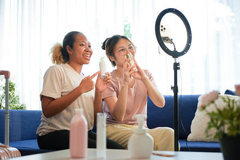 blogger kecantikan beragam live streaming ulasan produk makeup di media sosial, wanita muda merekam video untuk saluran vlogging dengan ring light, teman menjual produk kosmetik online dari rumah - content creator ring light potret stok, foto, &amp; gambar bebas royalti