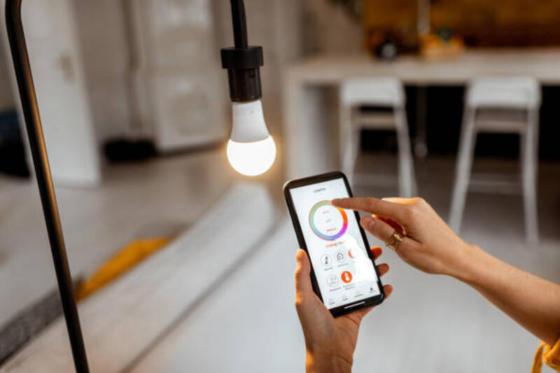 Controlling light bulb with mobile device Controlling light bulb temperature and intensity with a smartphone application. Concept of a smart home and managing light with mobile devices smart bulb stock pictures, royalty-free photos & images