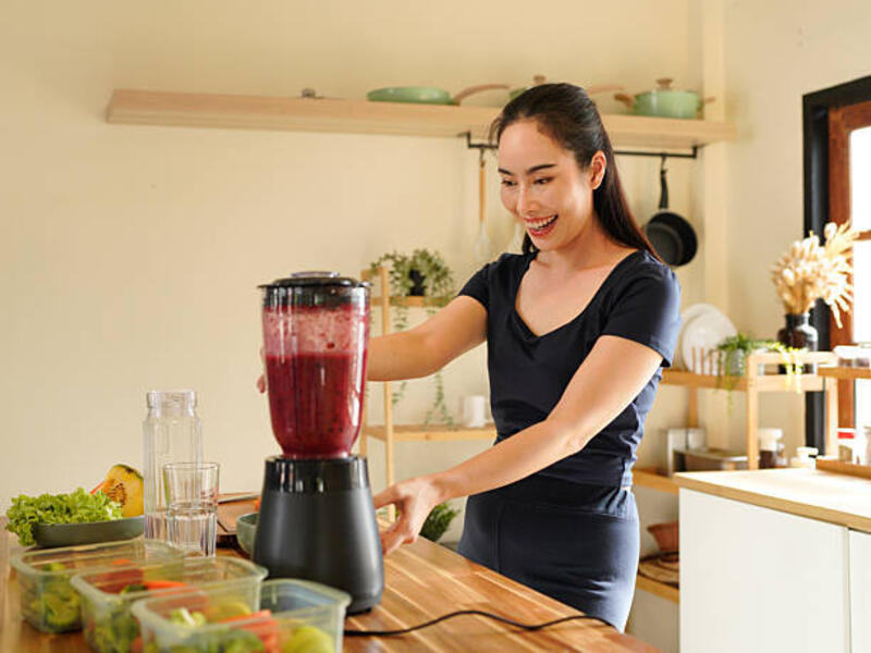 smiling-woman-making-a-colorful-fruit-smoothie-in-a-blender-at-a-bright-kitchen-setting-on-the.jpg (612×459)