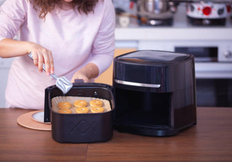 wanita memasak makanan dengan air fryer di dapur. - penggoreng udara potret stok, foto, &amp; gambar bebas royalti