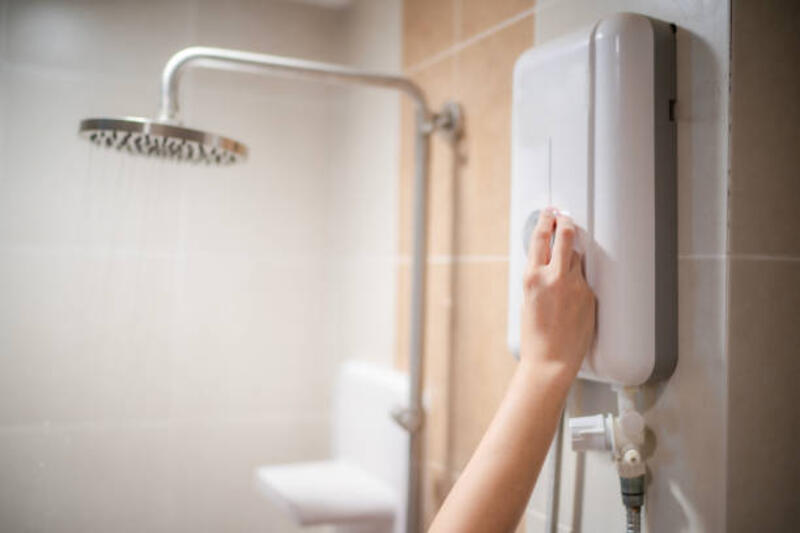 Woman hand adjust temperature at electric water boile. Woman hand adjust temperature at electric water boiler with shower and rain water blur background and space, woman using water boiler in bathroom at home. water heater stock pictures, royalty-free photos &amp; images