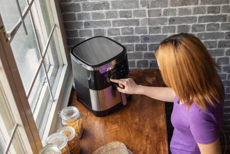 gadis remaja cantik menggunakan air fryer di dapur - penggoreng udara potret stok, foto, &amp; gambar bebas royalti