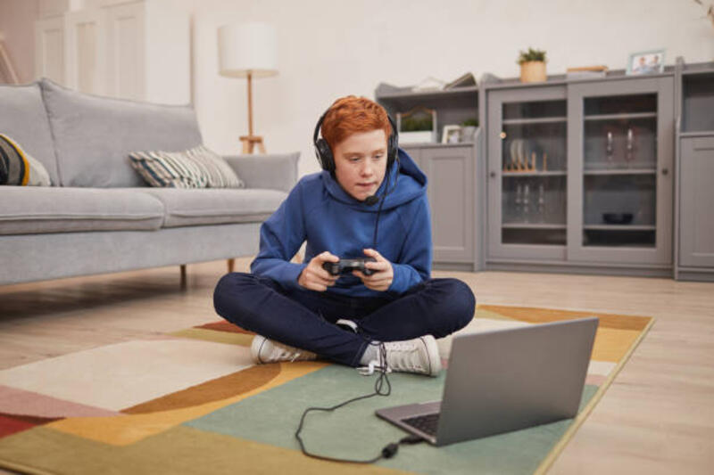 bocah berambut merah bermain video game di lantai - gaming laptop potret stok, foto, & gambar bebas royalti