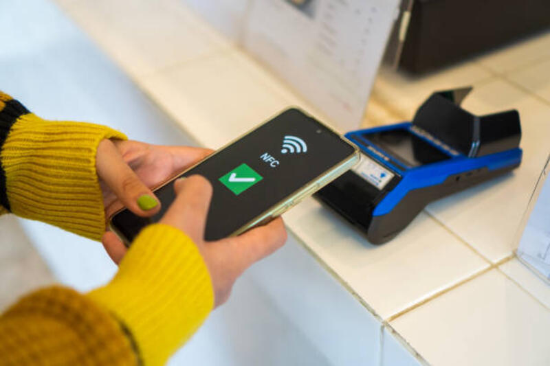 close-up-of-a-females-hand-paying-bill-with-credit-card-contactless-payment-on-smartphone-in.jpg (612×408)
