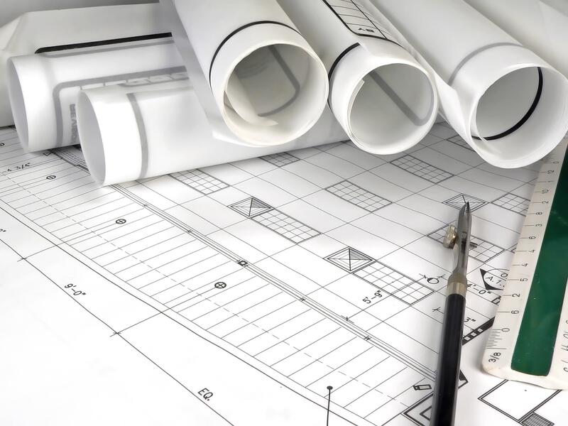 Image of a technical printer or plotter printing a large architectural blueprint