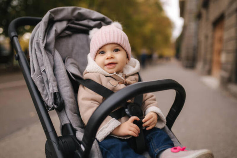 bayi kecil yang lucu di pram. menggemaskan bayi perempuan di musim gugur duduk di pram nya - stroller bayi potret stok, foto, &amp; gambar bebas royalti