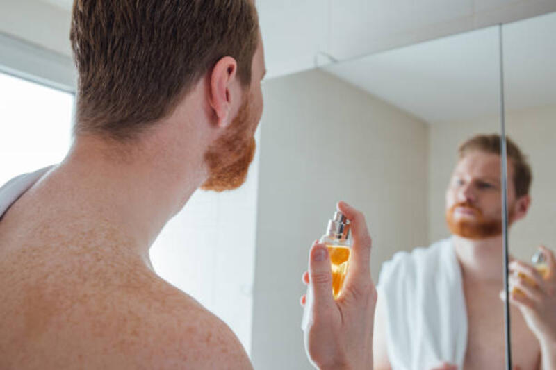 seorang pria menaruh parfum di kamar mandi - pria menyemprotkan parfum potret stok, foto, &amp; gambar bebas royalti